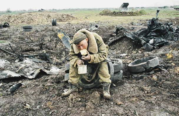Рис. 6. Солдатский обед. Чечня. 1 апреля 1999 г. На втором плане БМ РСЗО «Град». Фото: В. Вяткин, РИА «Новости»