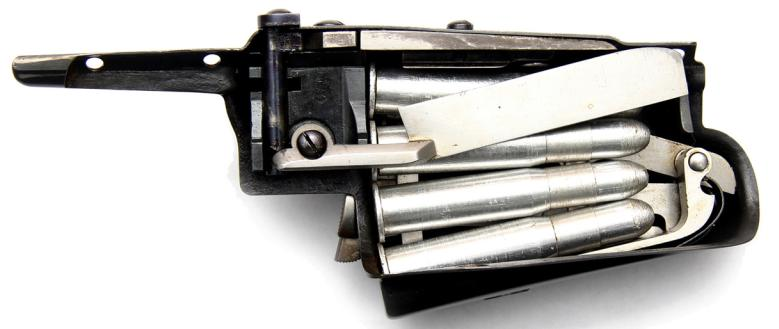 Ил. 13. Внутренний вид заполненного магазина емкостью восемь патронов; в конструкцию этого магазина входит разобщитель (в модели 1885 г. разобщитель входит в конструкцию ствольной коробки), на снимке магазин находится в отключенном состоянии Ил. 13. Внутренний вид заполненного магазина емкостью восемь патронов; в конструкцию этого магазина входит разобщитель (в модели 1885 г. разобщитель входит в конструкцию ствольной коробки), на снимке магазин находится в отключенном состоянии